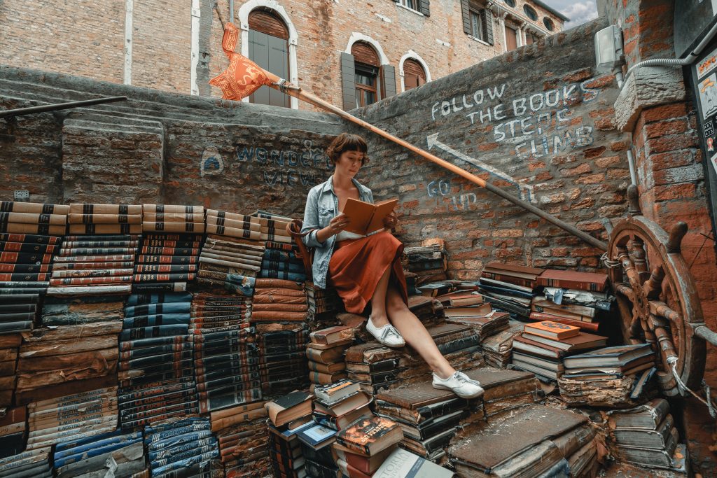 Femme qui lit sur une montagne de livre